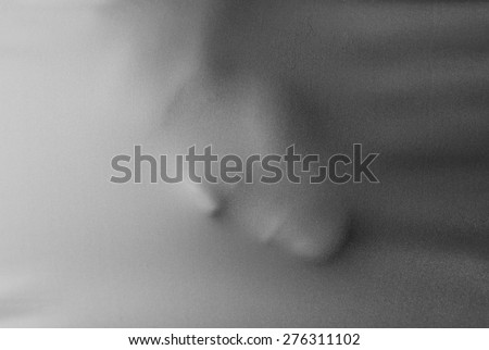 Human face pressing through fabric as horror background