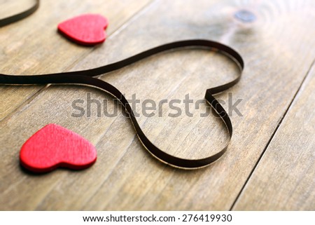 Magnetic tape in shape of heart on wooden background