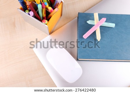 Books, computer mouse and pieces of chalk on wooden table background