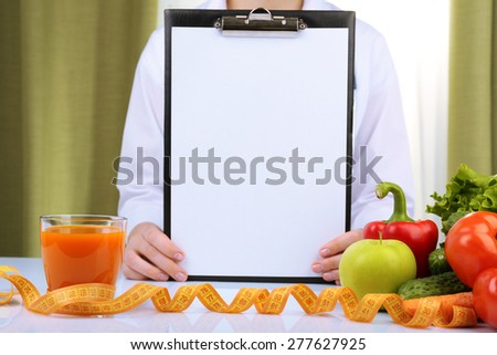 Nutritionist doctor with clipboard for diet plan in office