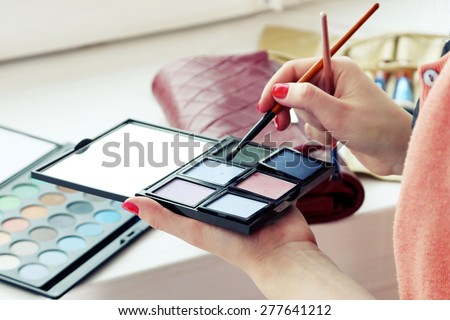 Female makeup artist with cosmetics at work close-up