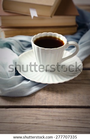 Still life with cup of coffee and books, on wooden table