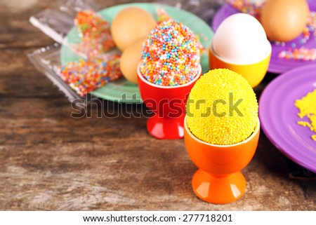 Decoration Easter eggs with colorful beads on wooden table, closeup