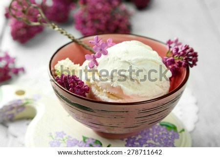 Beautiful composition with tasty ice cream and lilac flowers