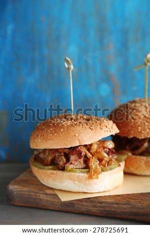 Tasty sandwich on cutting board, on color wooden background. Unhealthy food concept