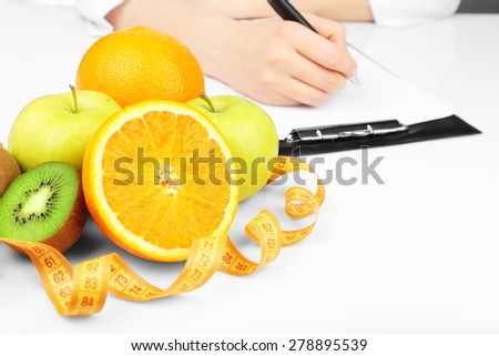 Nutritionist doctor writing  diet plan in office
