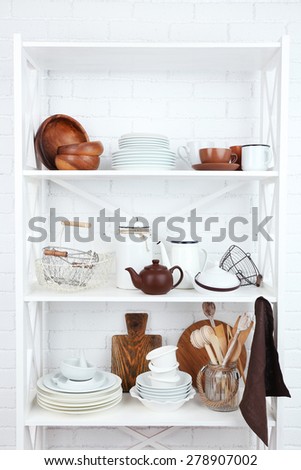 Kitchen shelving with dishes on white brick wall background