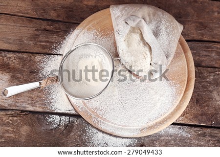 White flour on cutting board on wooden table background