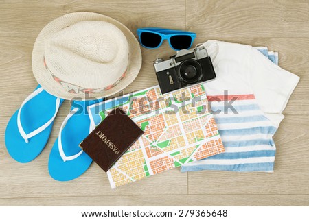 Summer vacation clothes, shoes and hat on wooden background