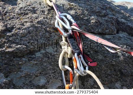 Rock climbing rope with hooks on  rock, close-up