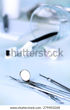 Dentist tools with toothpaste and brushes on table close up