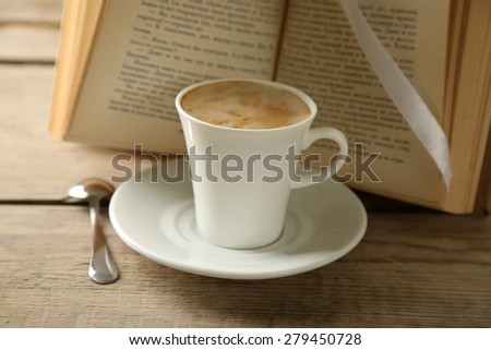 Still life with cup of coffee and book, on wooden table