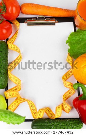 Clipboard for diet plan with vegetables and measuring tape, closeup