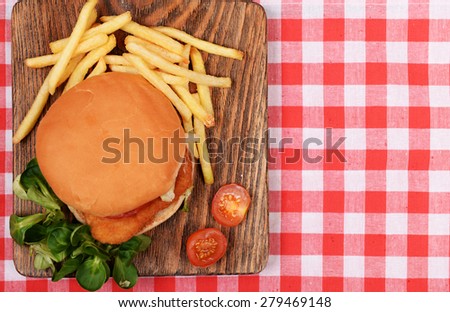 Hamburger, french fries and tomato on table top view