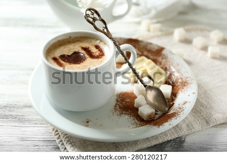 Cup of latte coffee art on wooden table, on light background