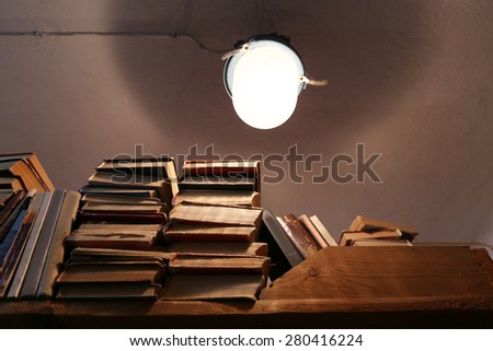 Many books on bookshelf with light bulb in library
