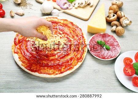 Woman making pizza on table close up