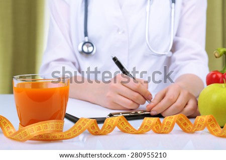 Nutritionist doctor writing  diet plan in office