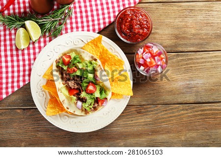 Mexican food Taco in plate on wooden table, top view