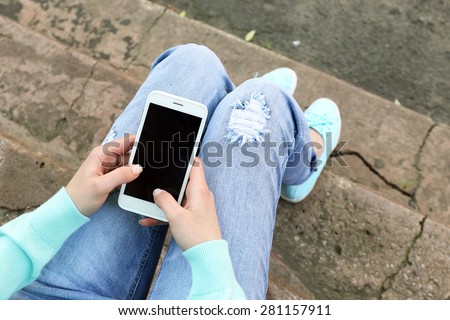 Woman with mobile phone, outdoors