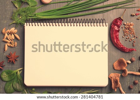 Recipe book page with different herbs on wooden background