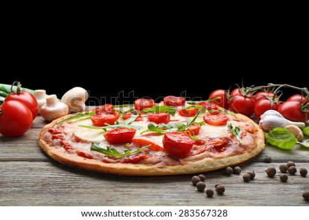 Delicious pizza with cheese and cherry tomatoes on wooden table on dark background