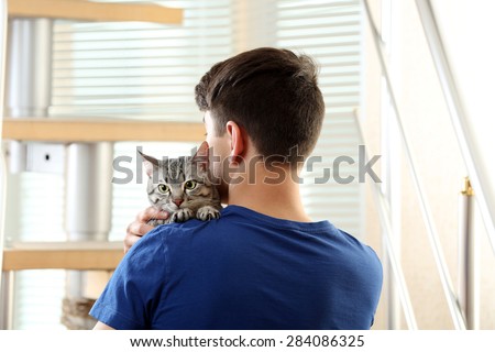 Young man with cute cat at home