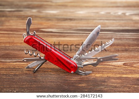 Multipurpose knife on wooden background