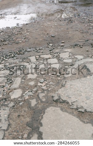 Very bad quality road with potholes and puddles