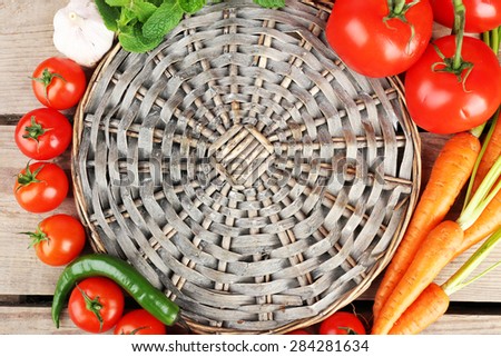 Fresh vegetables with wicker mat on wooden table