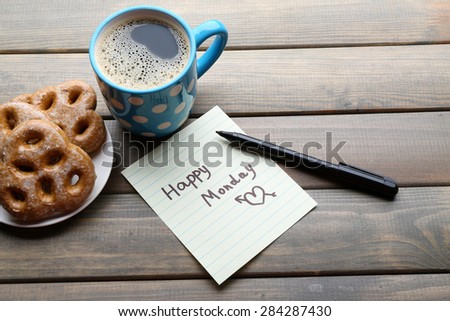 Cup of coffee with fresh cookies and Happy Monday massage on wooden background