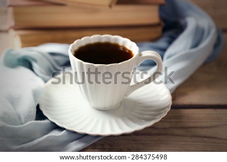 Still life with cup of coffee and books, on wooden table