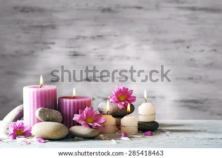 Beautiful composition with candles and spa stones on wooden background