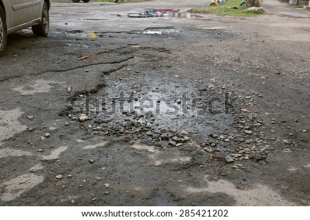 Very bad quality road with potholes and puddles