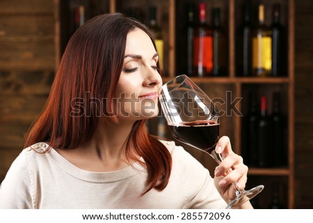 Young woman tasting wine in cellar