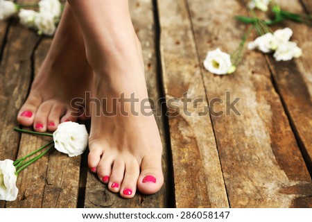 Beautiful female legs on rustic wooden floor background