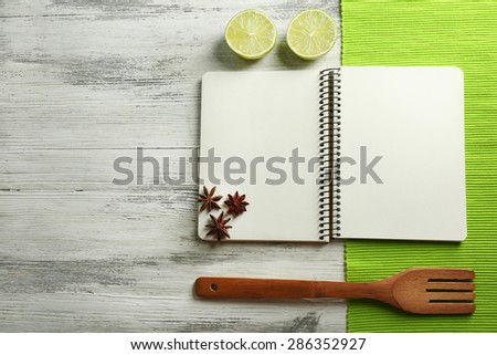 Open recipe book, napkin on wooden background