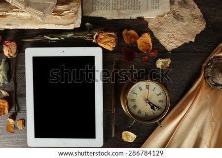 Ancient things and tablet on wooden background