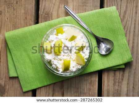 Cottage cheese with green apple on wooden table, closeup