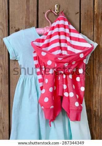 Child dress on hanger on wooden wall background