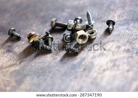 Heap of nuts and bolts on table close up