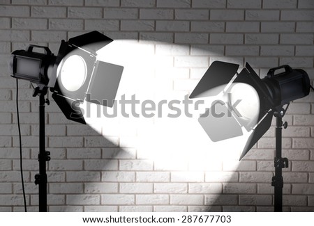 Photo studio with lighting equipment on brick wall background