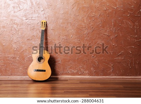 Classical acoustic guitar on brown wall background