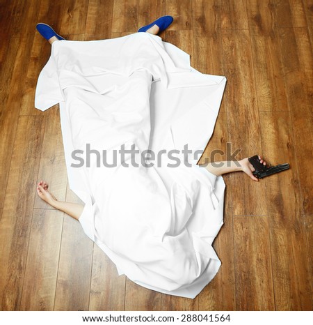 Crime scene simulation, young man lying with gun on floor