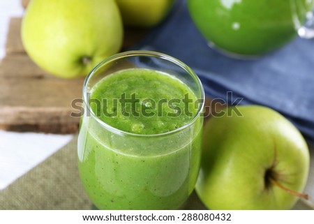 Healthy green smoothie with green apples on sackcloth, closeup