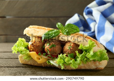 Homemade Spicy Meatball Sub Sandwich on wooden table background