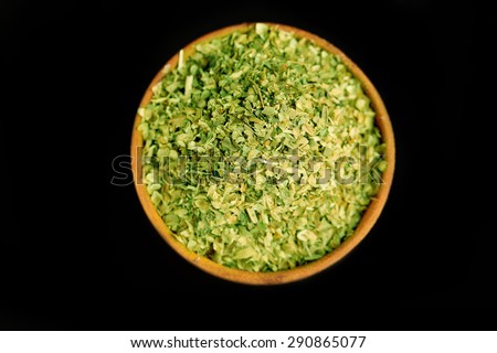 Dried parsley in wooden bowl, on black background