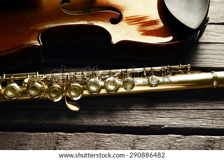 Flute with violin on table close up