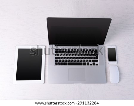 Laptop, mouse, tablet and mobile phone on white table, top view
