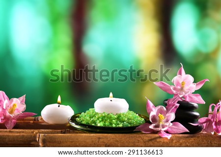 Beautiful spa composition with flowers and candles on bright background